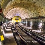Dramatic view of a Berlin subway tunnel with train approaching, showcasing modern infrastructure.