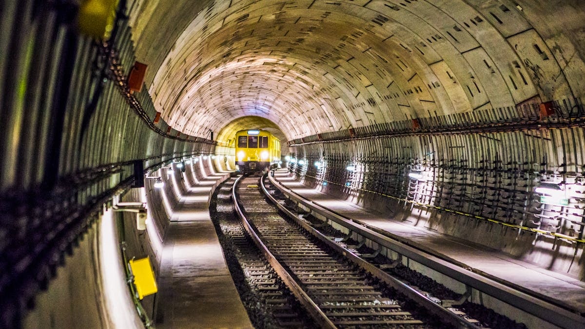 Dramatic view of a Berlin subway tunnel with train approaching, showcasing modern infrastructure.